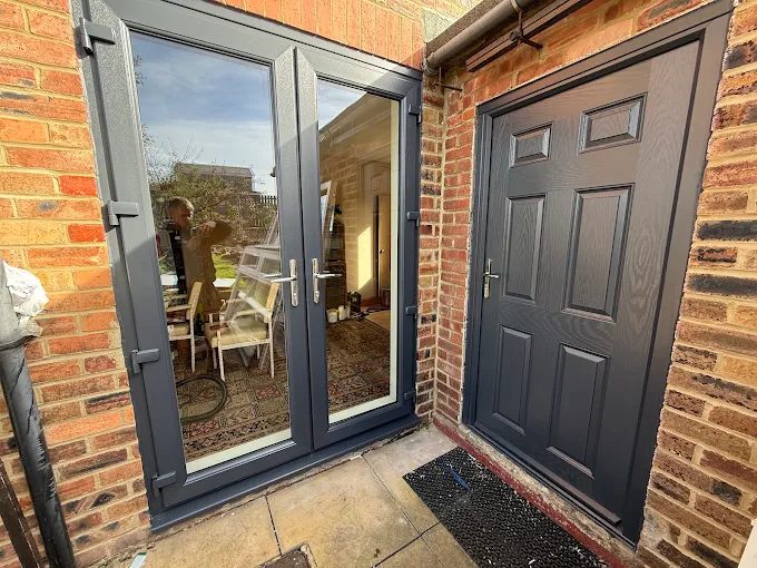 Anthracite French doors beside a matching anthracite six-panel back door on a red-brick house