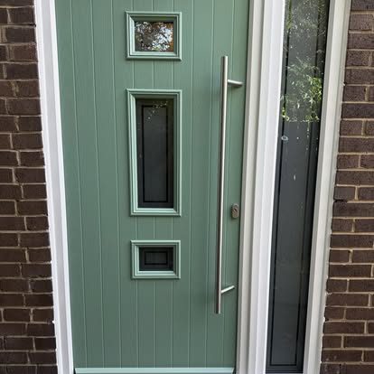 Green composite front door with three glazed openings and a full-height stainless bar handle